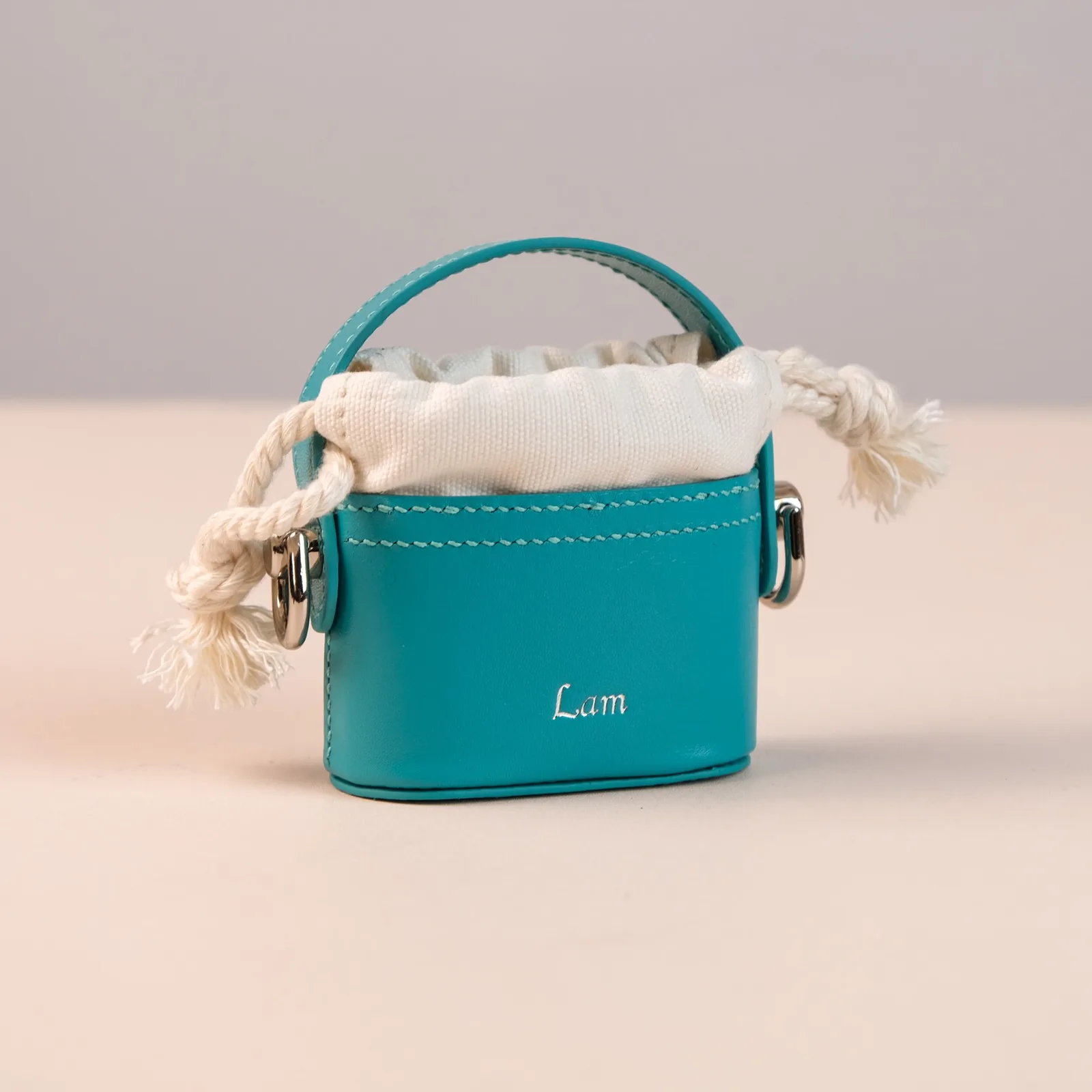 Ảnh Studio Túi da mini đựng tai nghe dáng bucket phối vải rút xanh teal - Koi Leather