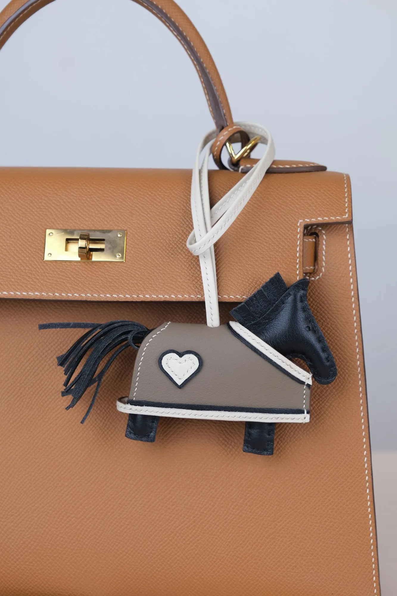 Ảnh Lifestyle Charm túi hình ngựa da Swift đen phối áo khoác tim - Koi Leather