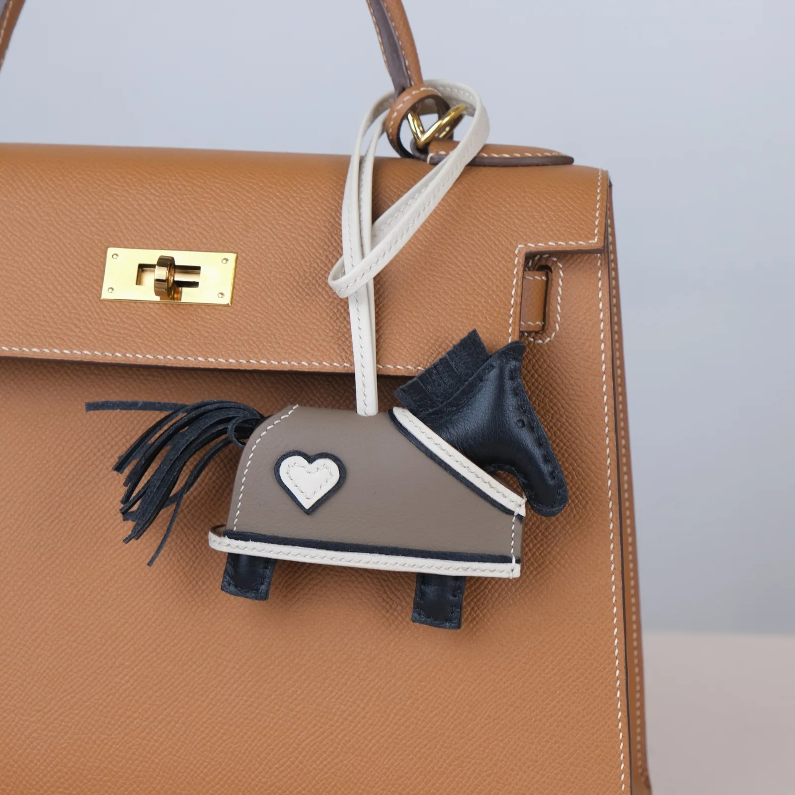 Ảnh Lifestyle Charm túi hình ngựa da Swift đen phối áo khoác tim - Koi Leather