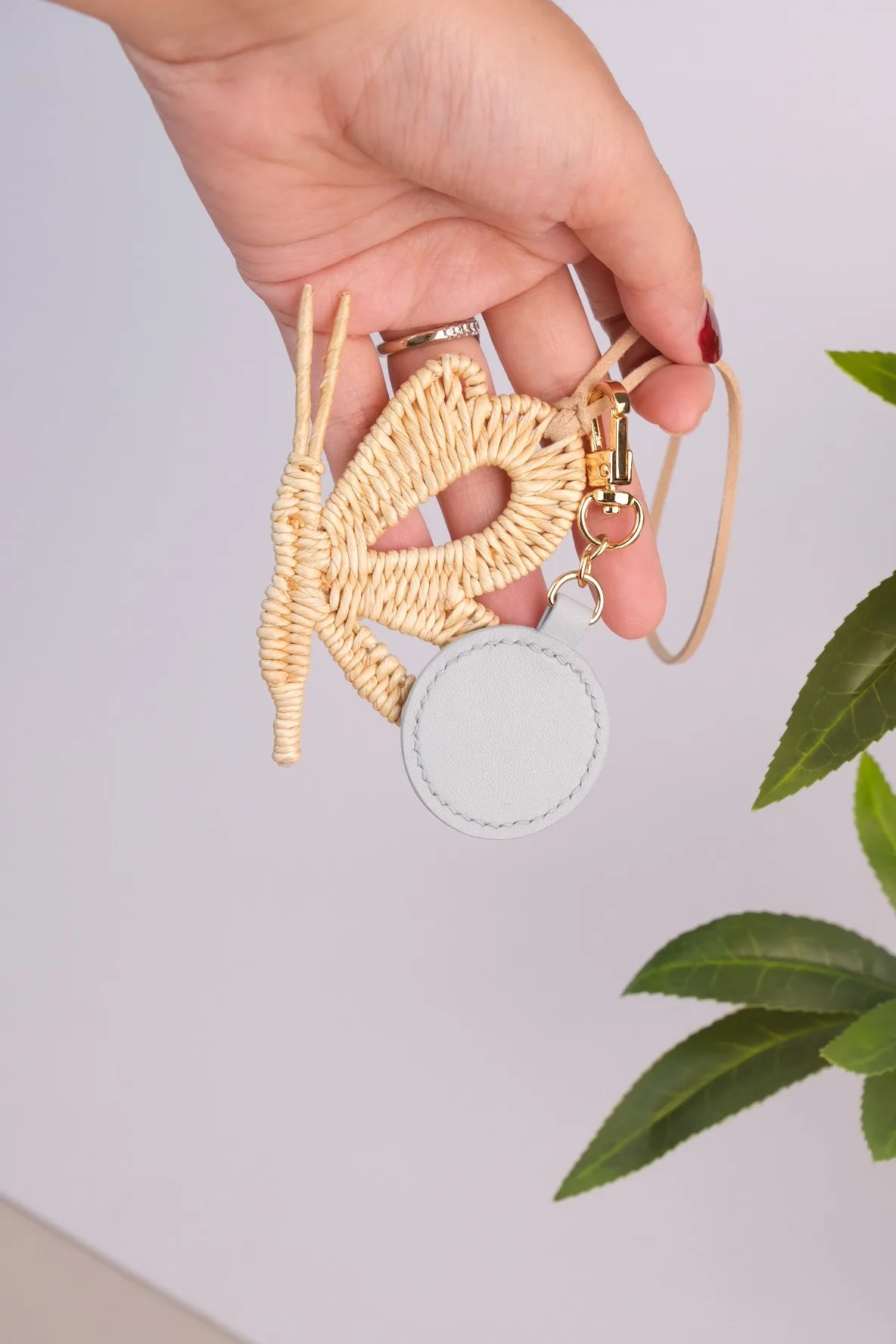 Ảnh Lifestyle Charm đeo túi hình bướm đan kèm tag da tròn - Koi Leather