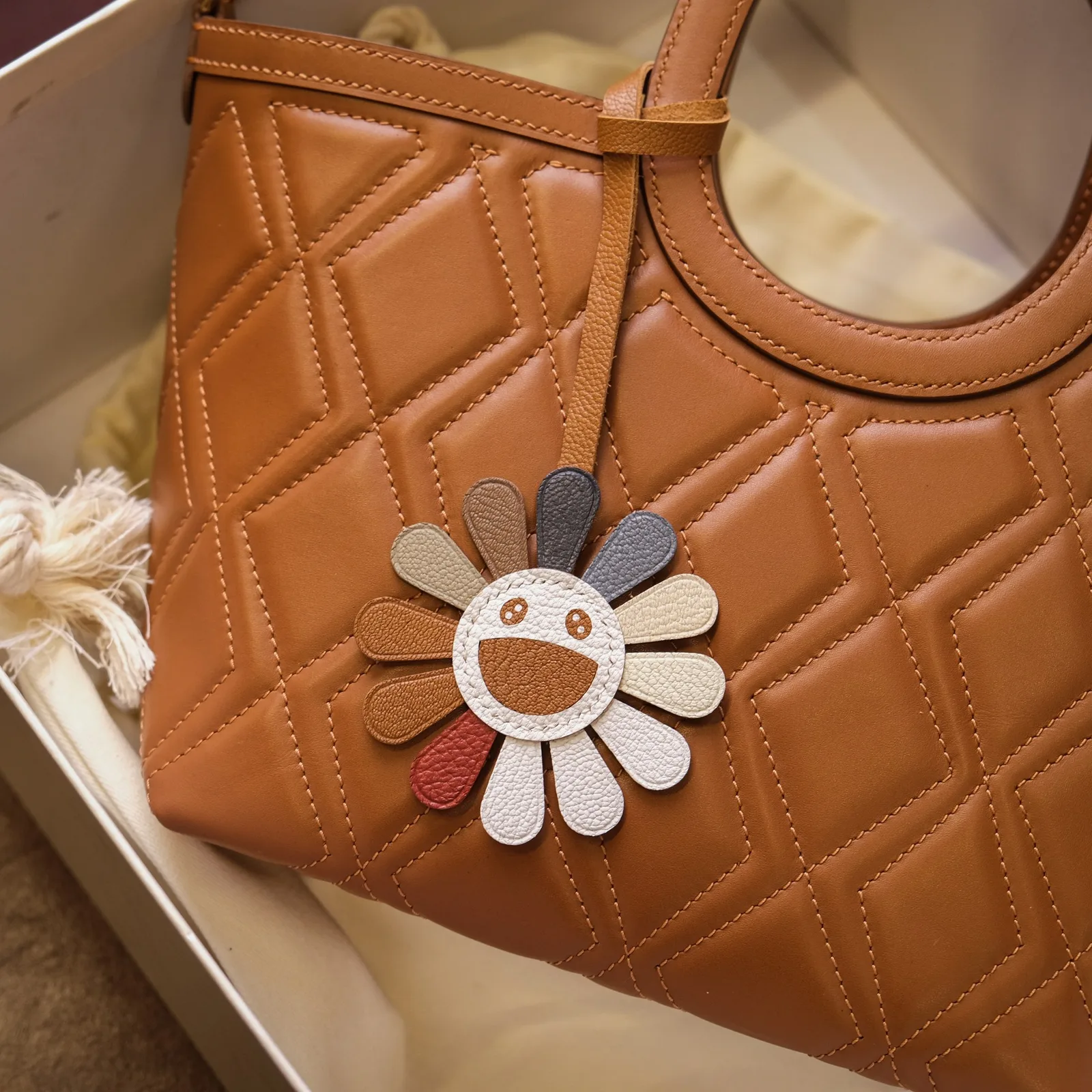 Ảnh Lifestyle Túi Revu da bò chần trám màu vàng bò kèm charm hoa - Koi Leather