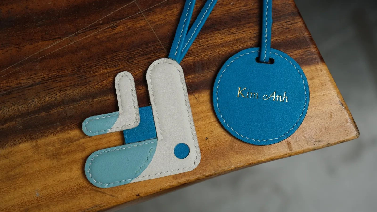 Ảnh Studio Charm đeo túi da phối màu hình cá kèm tag tròn - Koi Leather