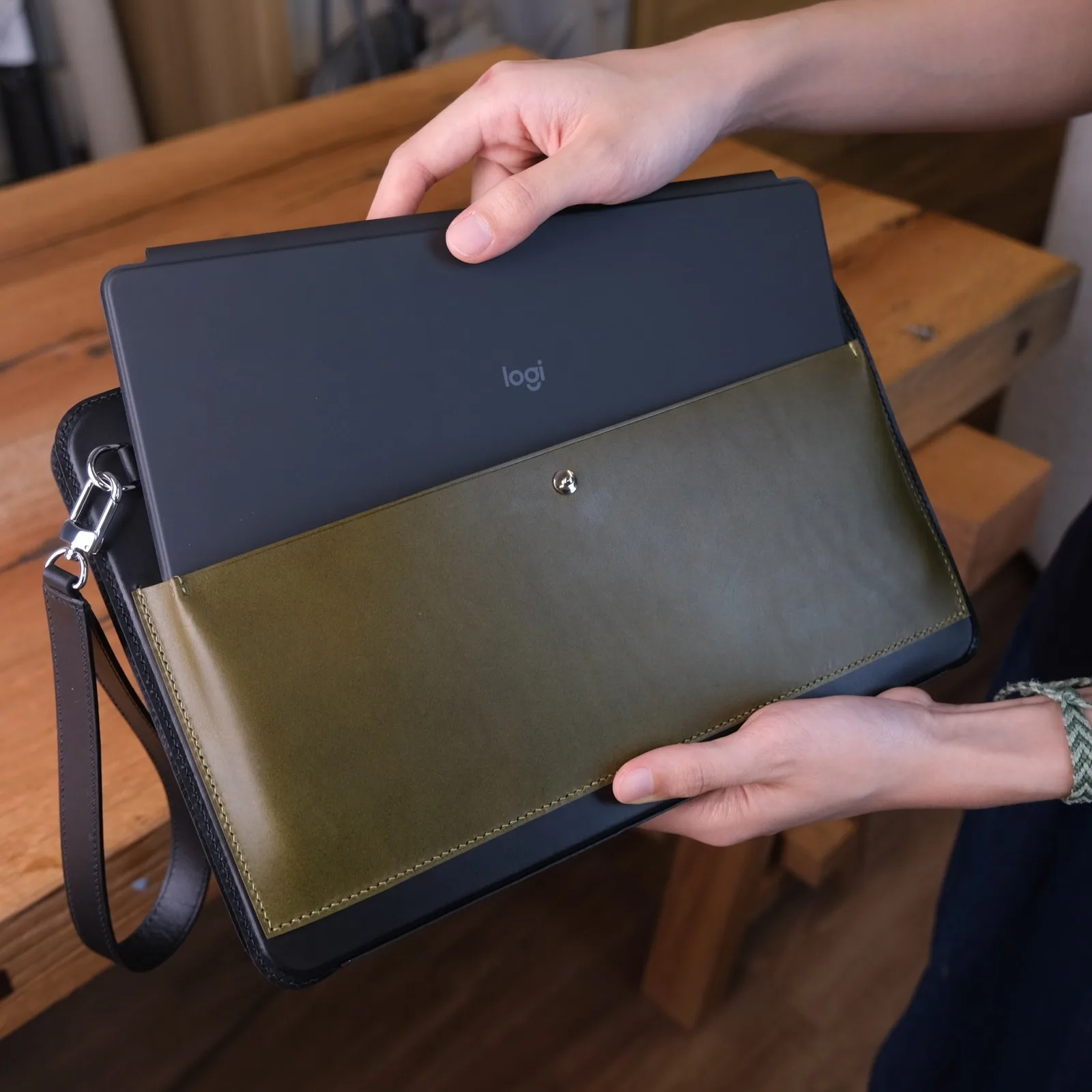 Ảnh Lifestyle Bao da iPad kiêm clutch cầm tay màu đen phối xanh olive - Koi Leather