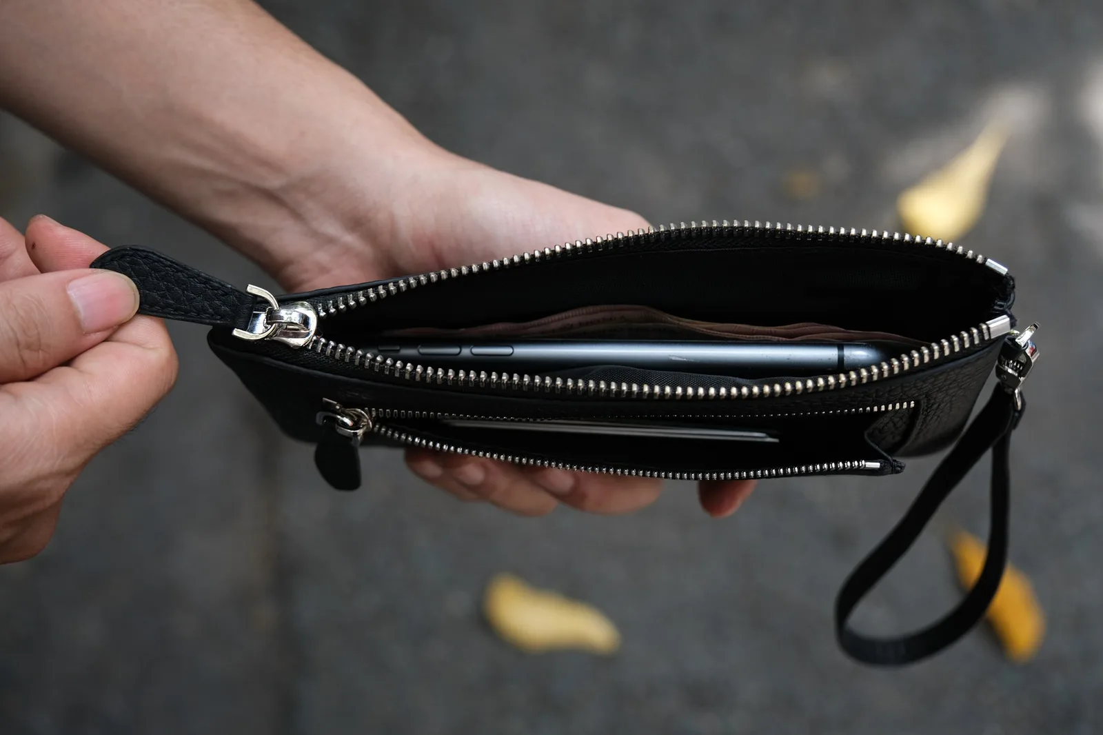 Ảnh Lifestyle Ví Monte zip wallet da bò hạt màu đen kèm quai tay - Koi Leather