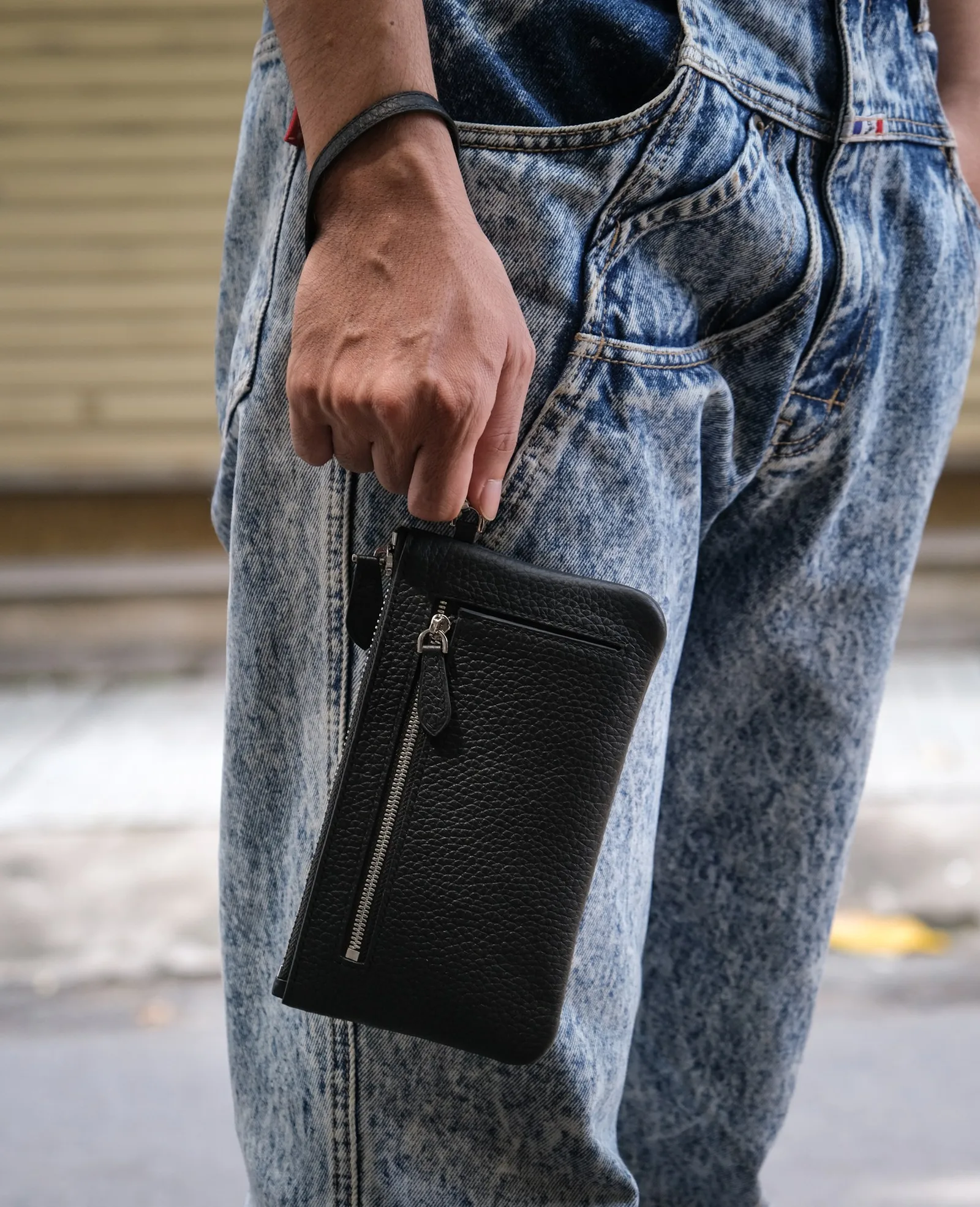 Ảnh Lifestyle Ví Monte zip wallet da bò hạt màu đen kèm quai tay - Koi Leather