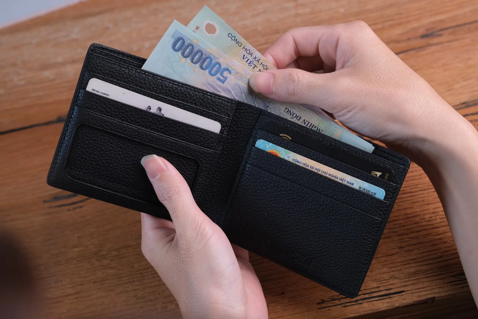Ảnh Lifestyle Ví ngang da bò Togo màu đen dáng gập đôi - Koi Leather