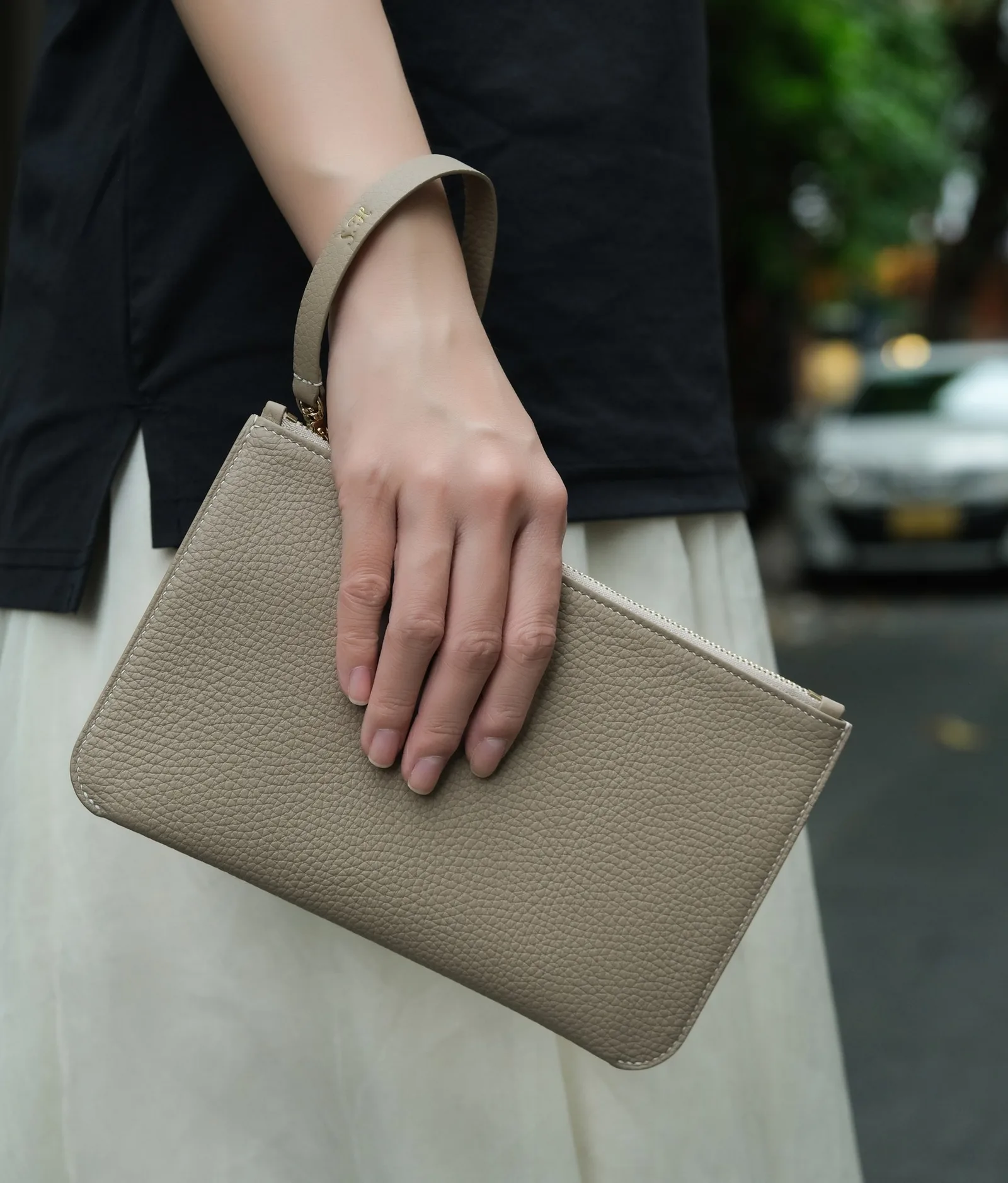 Ảnh Lifestyle Ví clutch da Togo màu kem dáng phẳng có quai đeo - Koi Leather