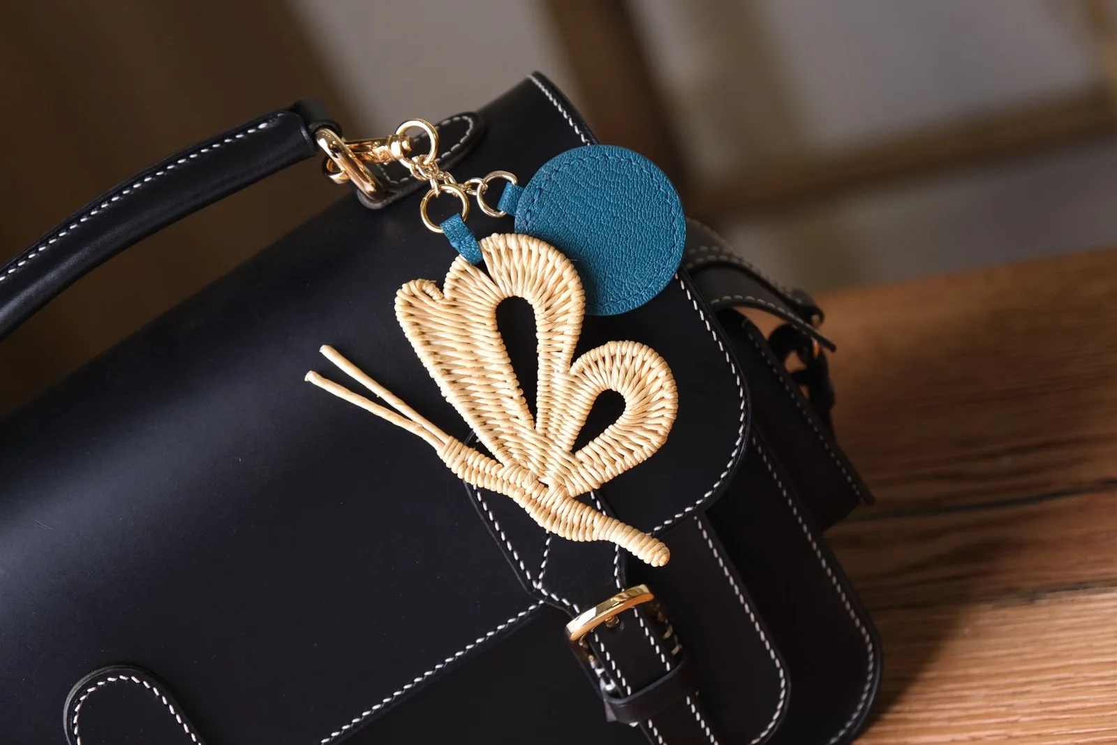 Ảnh Lifestyle Charm đeo túi hình bướm đan phối tag da tròn xanh dương - Koi Leather