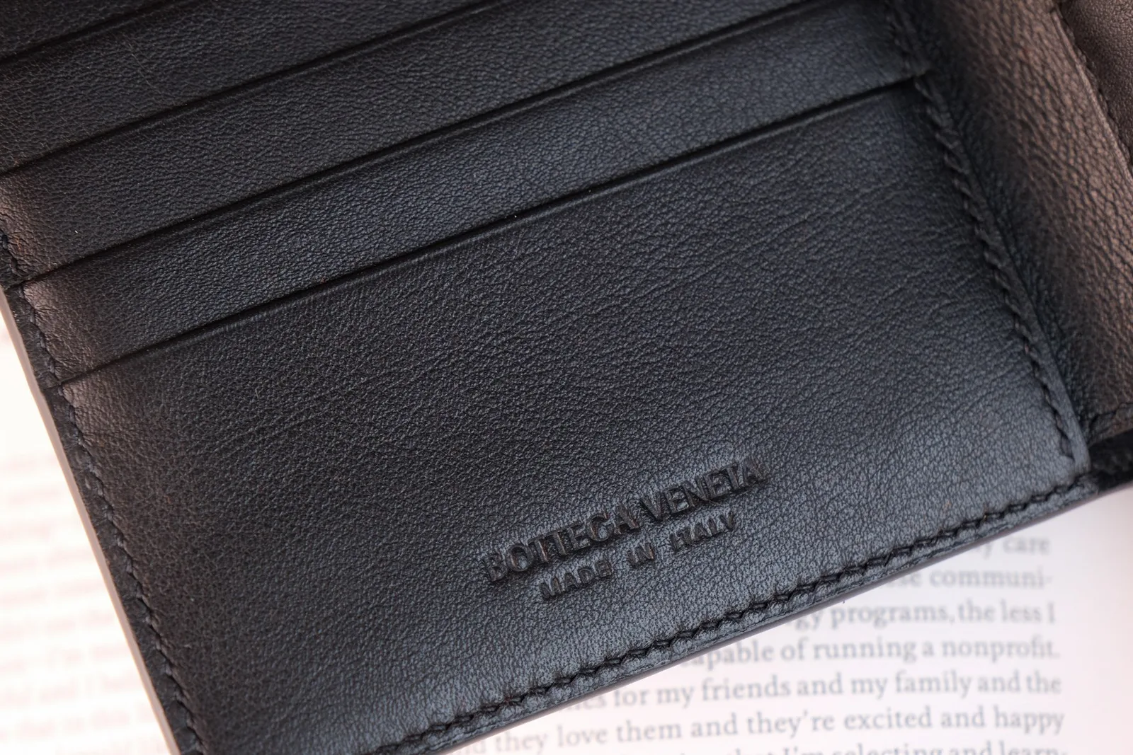 Cận cảnh logo Bottega Veneta dập chìm và đường chỉ khâu bên trong ngăn ví