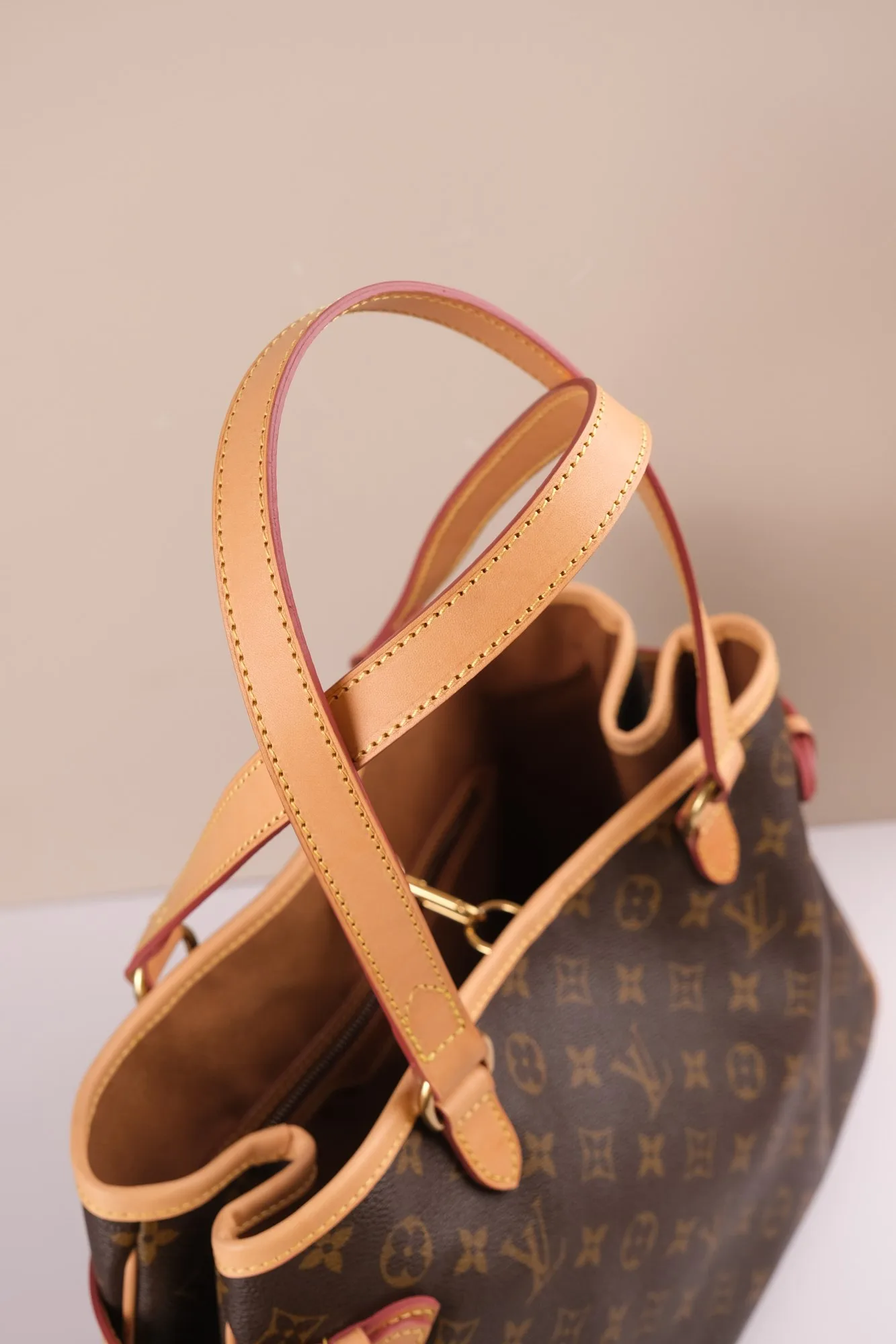 Chi tiết đường may quai xách và viền miệng da vachetta trên túi Louis Vuitton