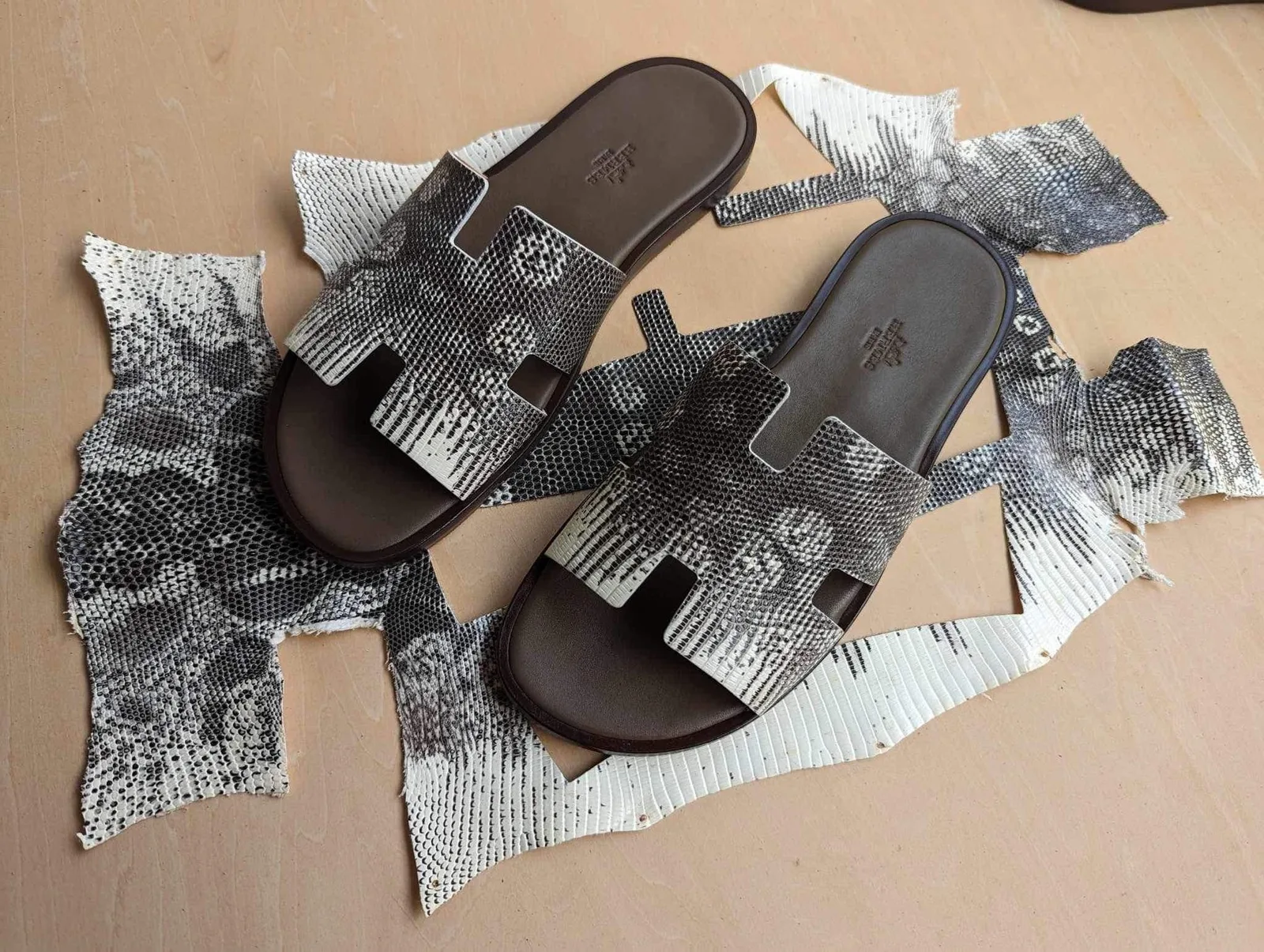 Dép Hermès Izmir độ quai da kỳ đà hoa văn tự nhiên đặt trên tấm da mộc