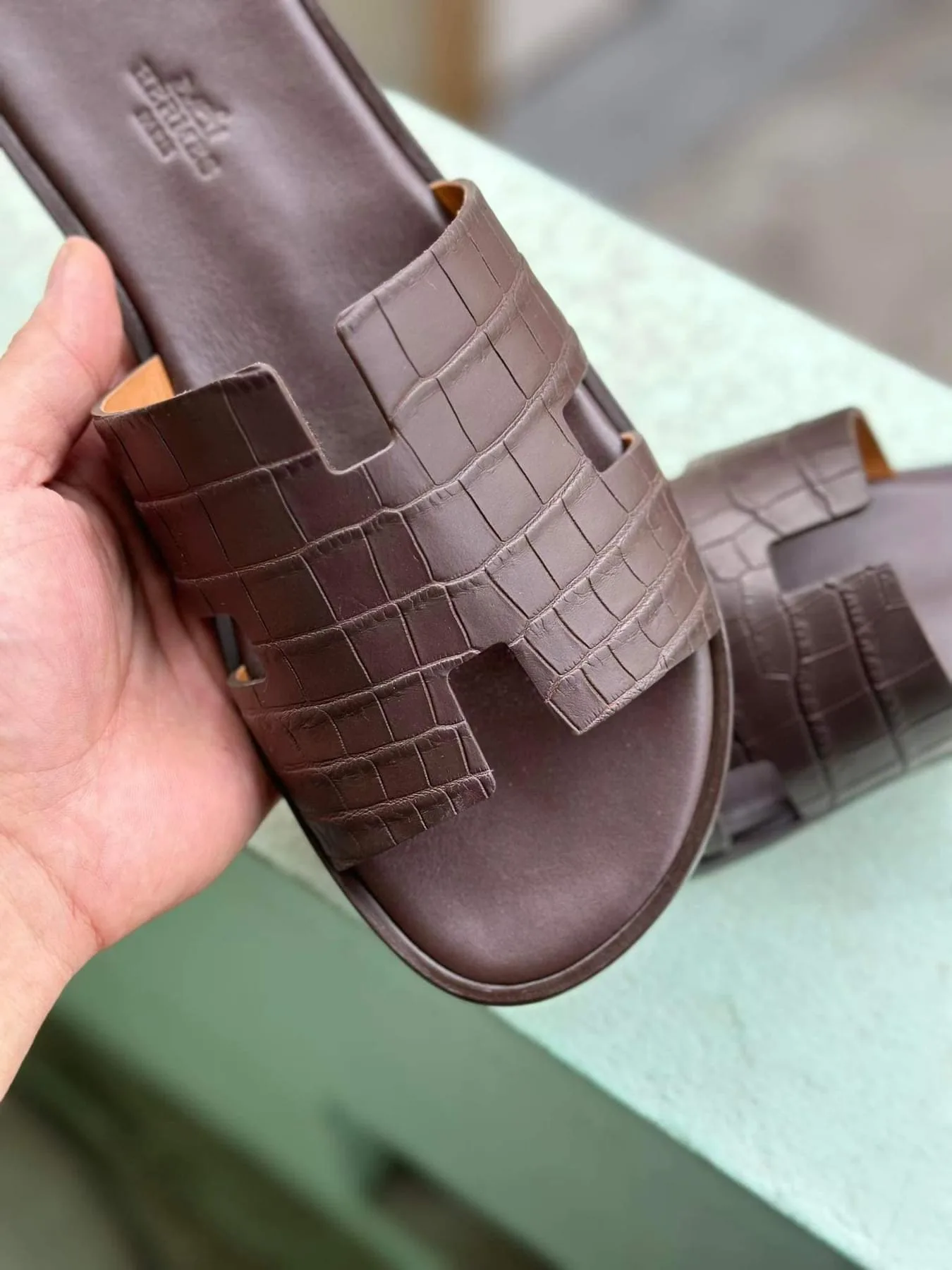 Cận cảnh quai dép Hermès Izmir may bằng da cá sấu màu nâu sẫm